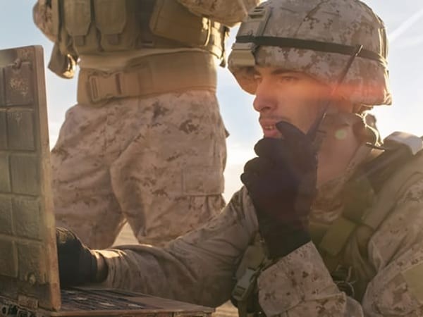 military personnel on the battlefield with field radio and laptop